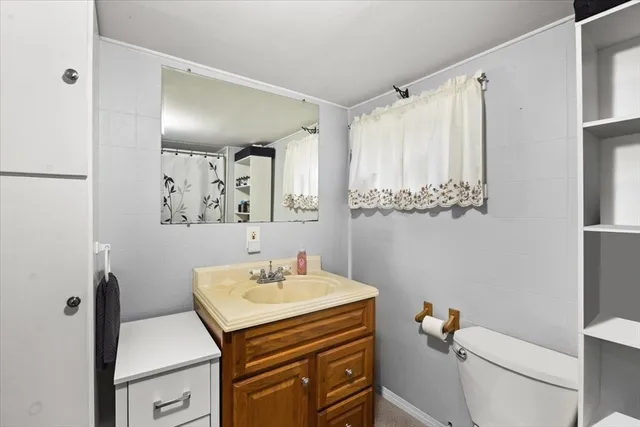 a bed sitting in a bedroom next to a window and dresser