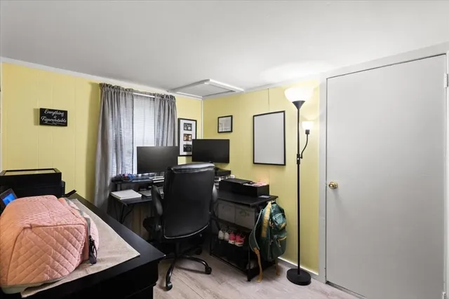 a view of a workspace with furniture and a window