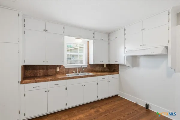 a kitchen with a sink cabinets and window