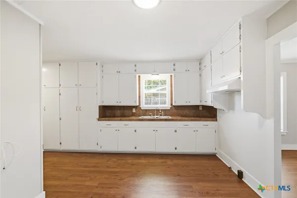 a kitchen with granite countertop white cabinets and white appliances