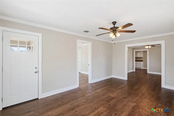 a view of an empty room with wooden floor