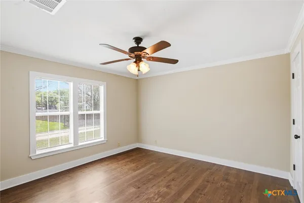 an empty room with a window and a fan