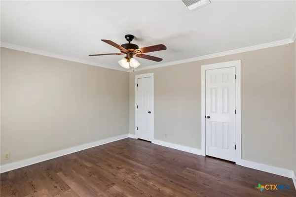 a view of a big room with wooden floor and a chandelier fan in a room