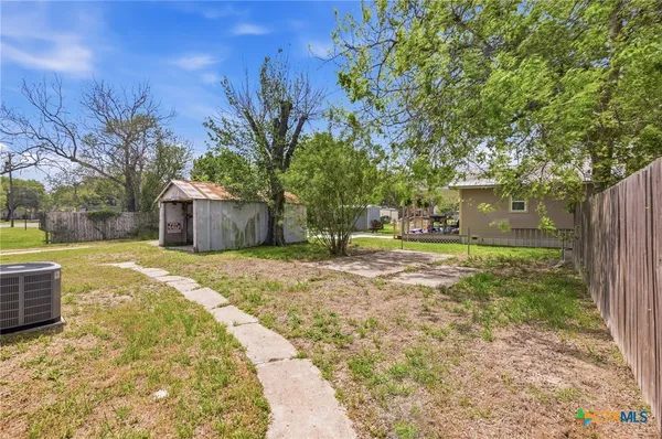 a view of a yard with plants and trees