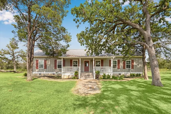 a front view of house with yard and green space