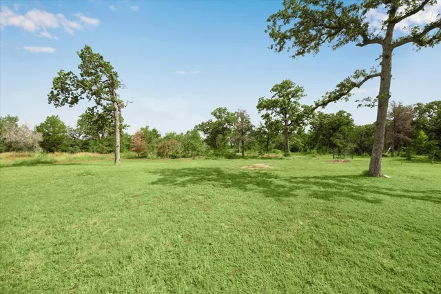 a view of a green field with wooden fence