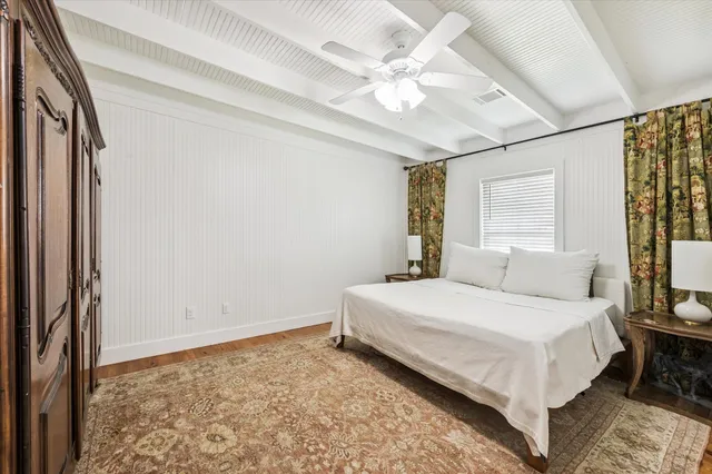 a spacious bedroom with a bed and a chandelier