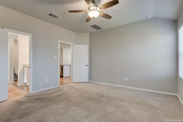 a view of an empty room and chandelier fan