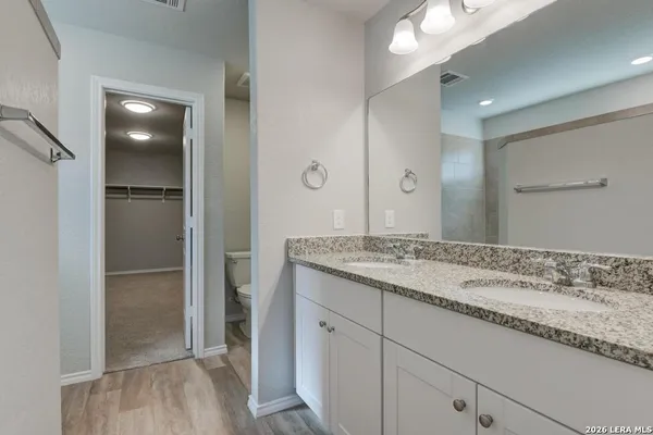 a bathroom with a granite countertop sink and a mirror
