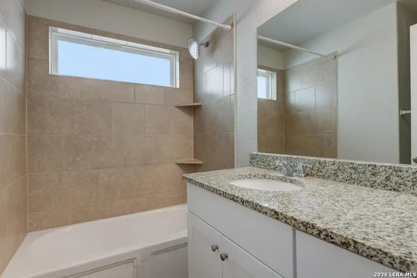 a bathroom with a granite countertop sink a toilet and bathtub