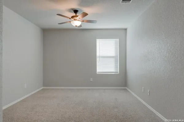 an empty room with a window and a fan