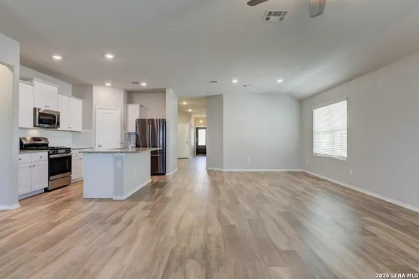 a view of kitchen with granite countertop stainless steel appliances refrigerator sink and microwave