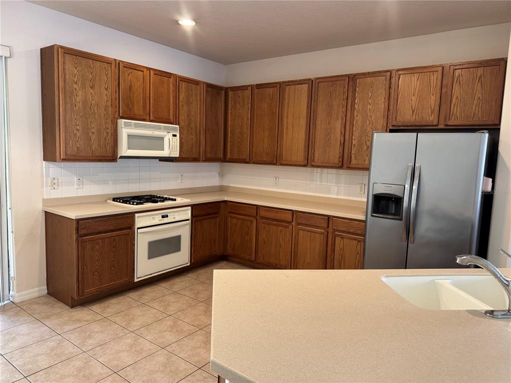 8237 Dunham Station Drive Tampa, FL 33647 - Photo 14 of 33 a kitchen with granite countertop a refrigerator stove top oven with a sink and dishwasher