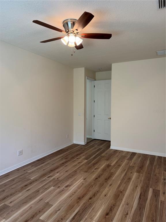 8237 Dunham Station Drive Tampa, FL 33647 - Photo 17 of 33 a view of a room with wooden floor and a ceiling fan