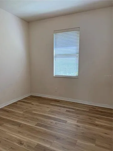 view of a hallway with wooden floor and closet area