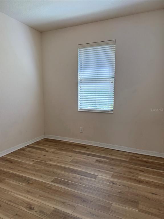 8237 Dunham Station Drive Tampa, FL 33647 - Photo 20 of 33 a view of an empty room with wooden floor and a window
