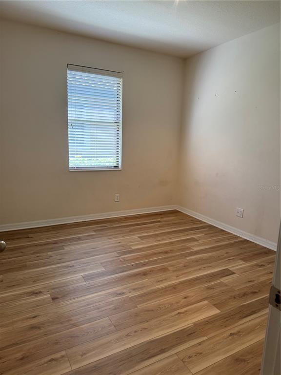8237 Dunham Station Drive Tampa, FL 33647 - Photo 22 of 33 an empty room with wooden floor and windows