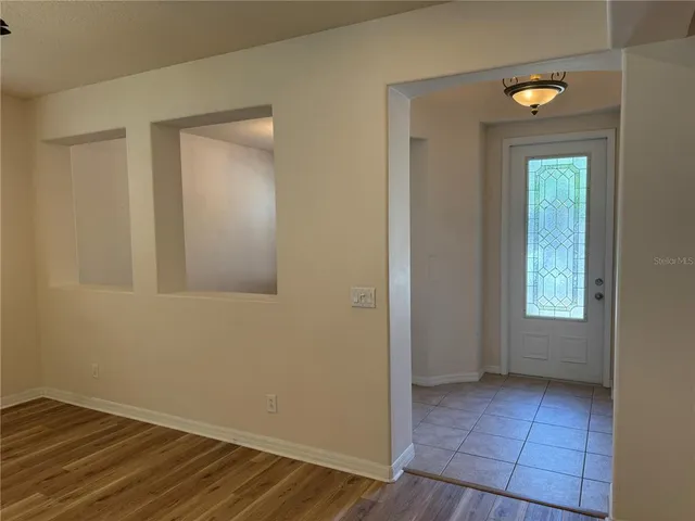 a view of an empty room with closet and a window