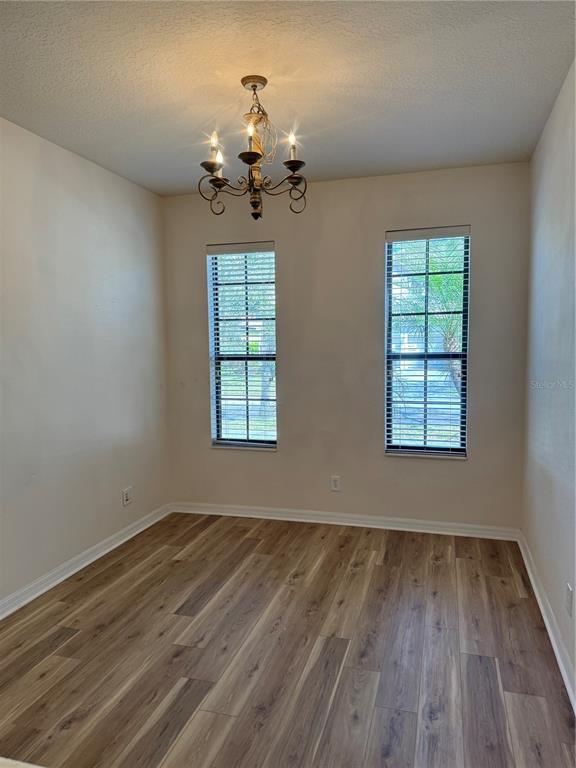 8237 Dunham Station Drive Tampa, FL 33647 - Photo 8 of 33 wooden floor in an empty room with a window