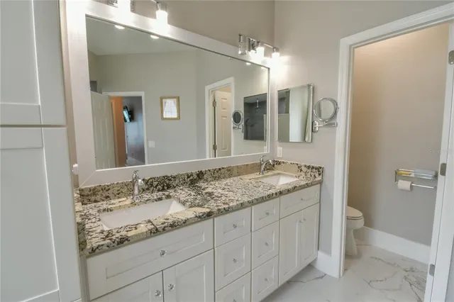 a large kitchen with granite countertop a lot of counter space and stainless steel appliances