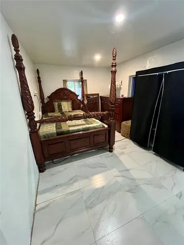 a spacious bedroom with a bed and a television