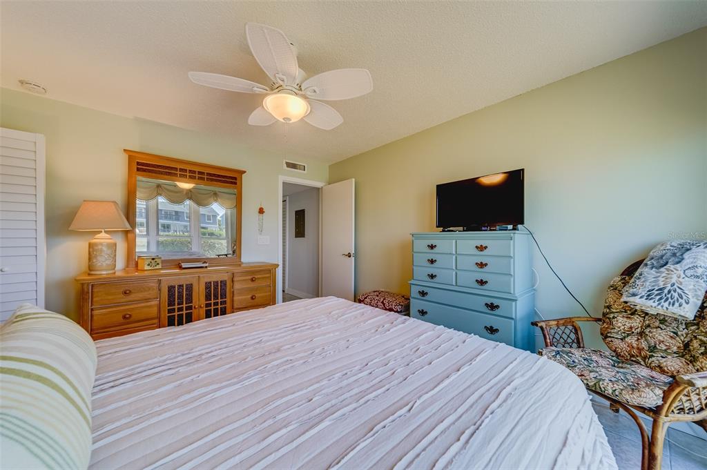 1 Windrush Boulevard, Unit 63 Indian Rocks Beach, FL 33785 - Photo 19 of 60 a bedroom with a bed and wooden floor