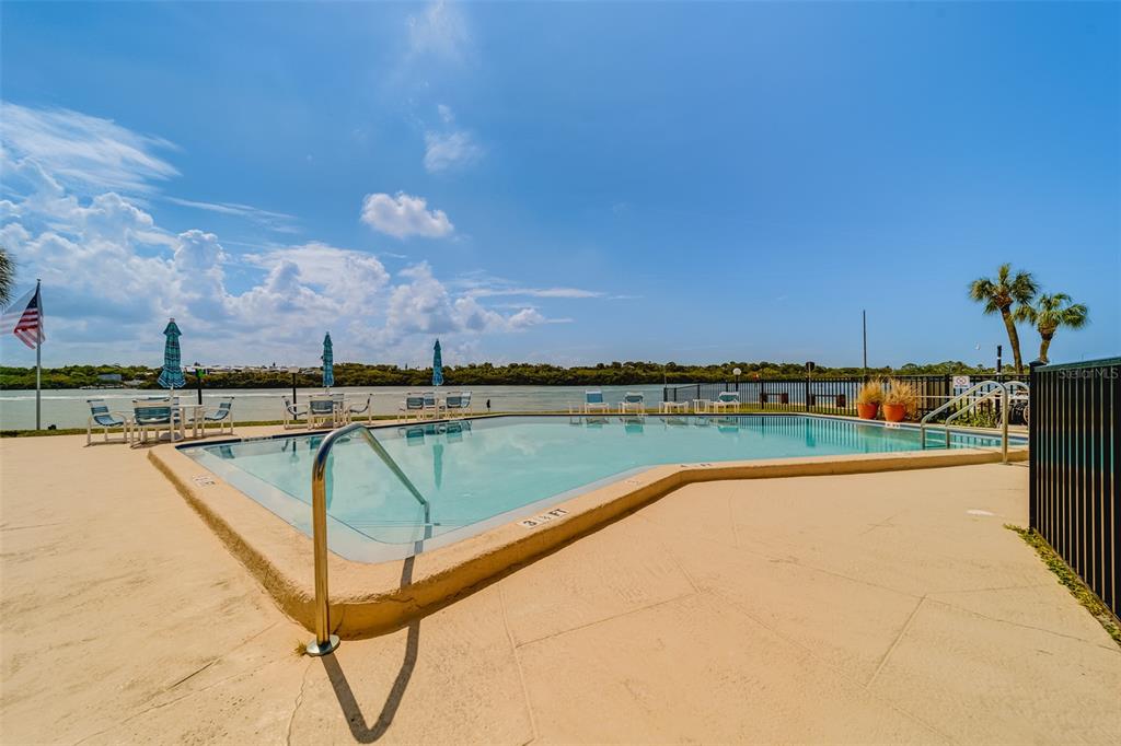1 Windrush Boulevard, Unit 63 Indian Rocks Beach, FL 33785 - Photo 29 of 60 a view of a swimming pool and an outdoor seating