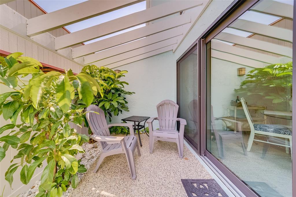 1 Windrush Boulevard, Unit 63 Indian Rocks Beach, FL 33785 - Photo 4 of 60 a view of a patio with table and chairs and potted plants