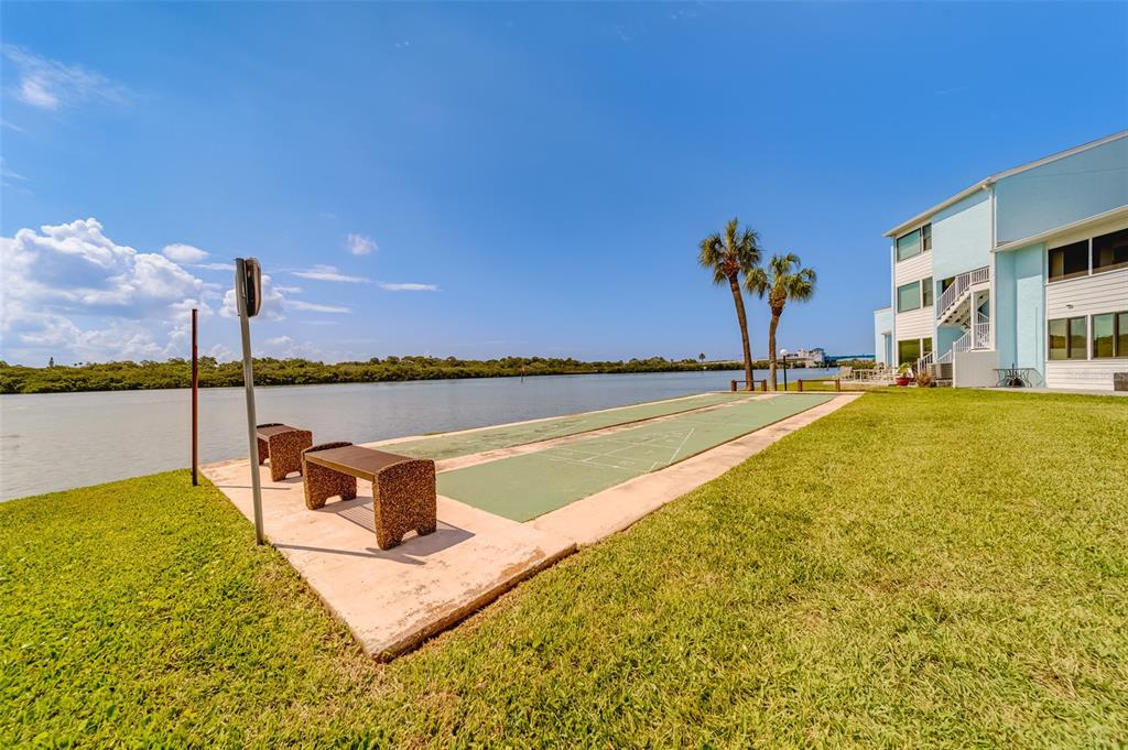 1 Windrush Boulevard, Unit 63 Indian Rocks Beach, FL 33785 - Photo 42 of 60 a view of a swimming pool with a table and chairs