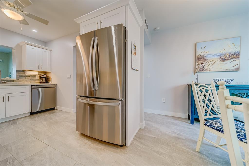 1 Windrush Boulevard, Unit 63 Indian Rocks Beach, FL 33785 - Photo 46 of 60 a kitchen with stainless steel appliances granite countertop a refrigerator and a stove top oven