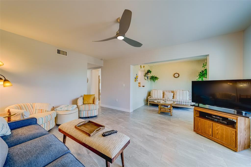 1 Windrush Boulevard, Unit 63 Indian Rocks Beach, FL 33785 - Photo 5 of 60 a living room with furniture and a flat screen tv