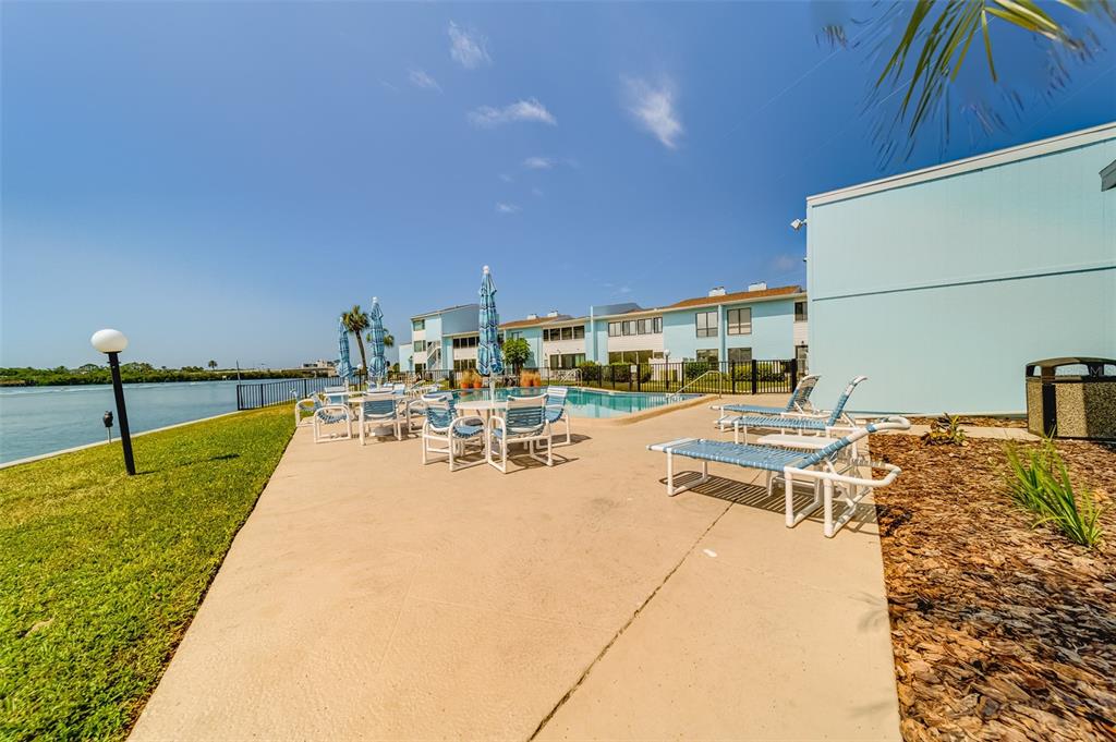 1 Windrush Boulevard, Unit 63 Indian Rocks Beach, FL 33785 - Photo 53 of 60 a swimming pool with outdoor seating and yard