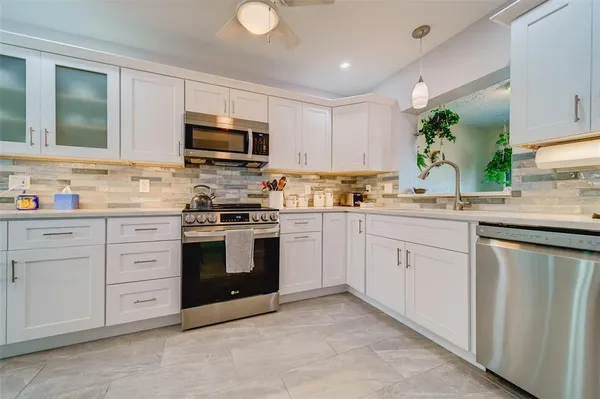 a kitchen with cabinets stainless steel appliances and a window