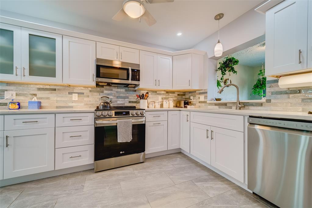 1 Windrush Boulevard, Unit 63 Indian Rocks Beach, FL 33785 - Photo 8 of 60 a kitchen with cabinets stainless steel appliances and a window