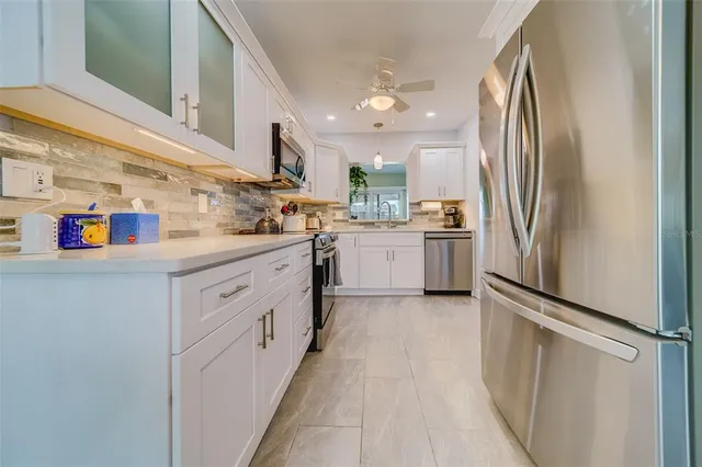 a kitchen with stainless steel appliances granite countertop a refrigerator and a stove