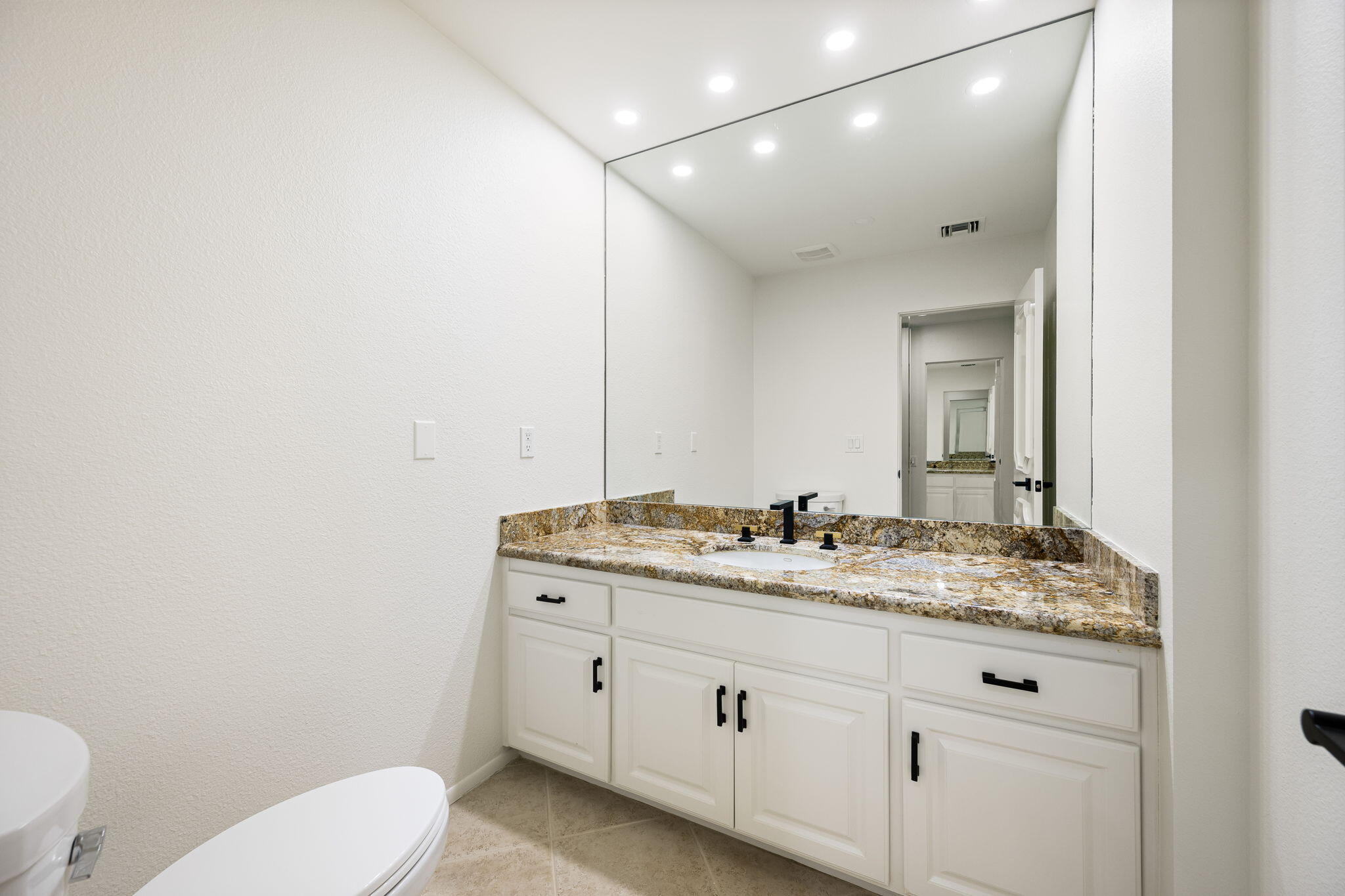 146 Yale Drive Rancho Mirage, CA 92270 - Photo 24 of 63 a bathroom with a granite countertop toilet sink mirror and vanity