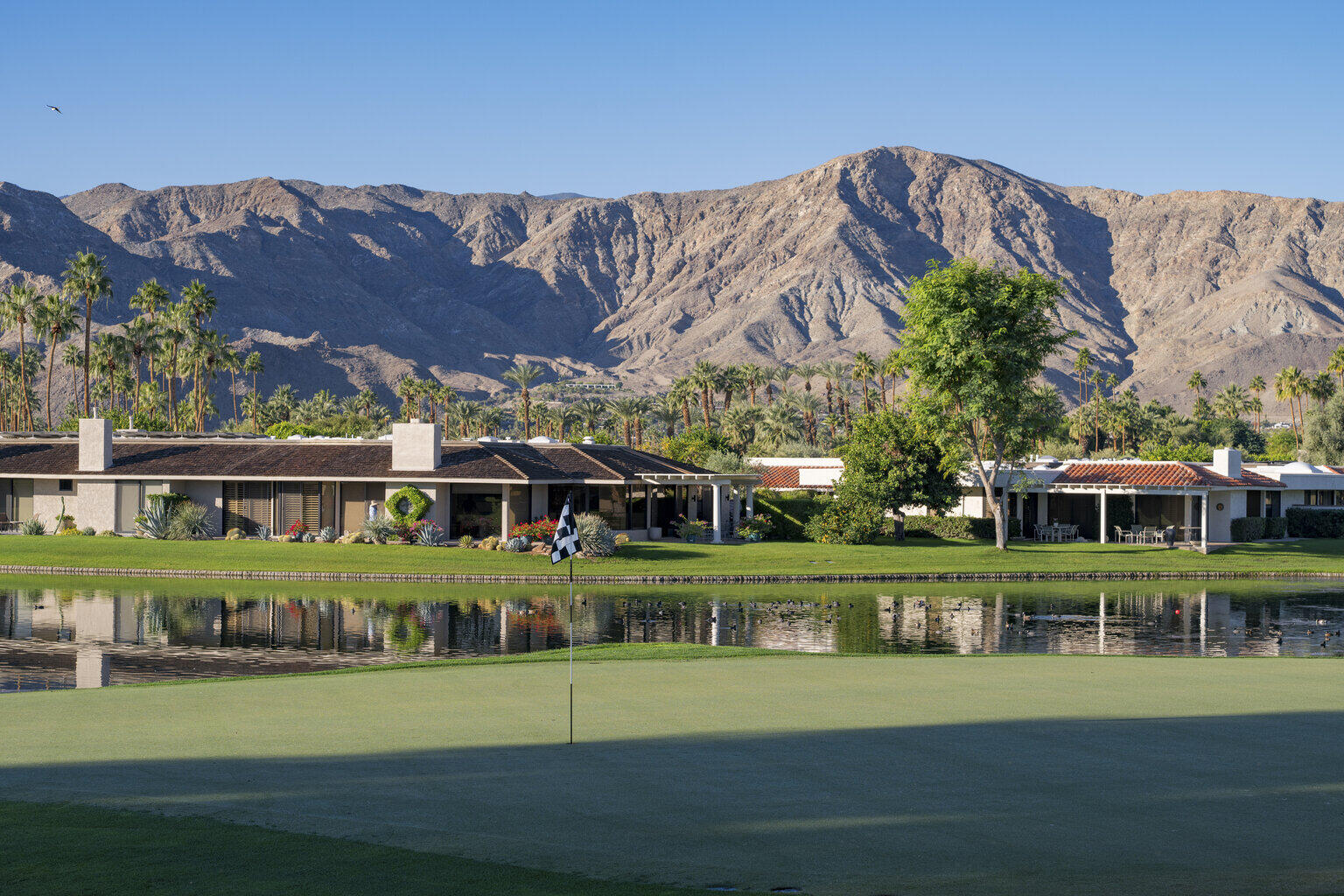 146 Yale Drive Rancho Mirage, CA 92270 - Photo 56 of 63 a front view of a house with a garden and lake view