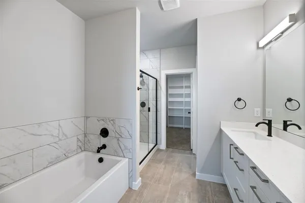 a bathroom with a tub sink and mirror