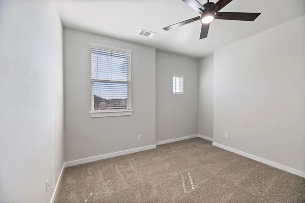 an empty room with a window and a fan
