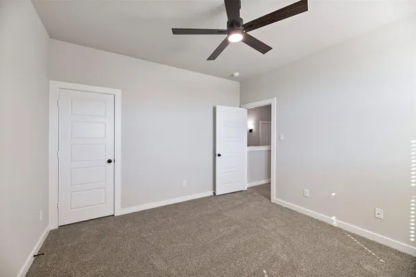 a view of an empty room and a ceiling fan