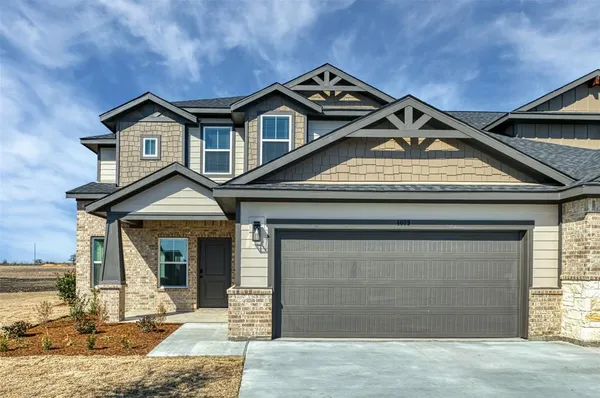 a view of a house with a yard and parking space