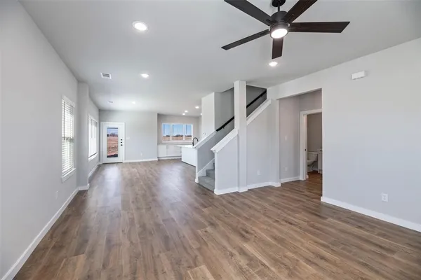 a view of a hallway with wooden floor and entryway