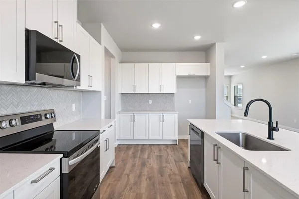 a kitchen with a sink a microwave and cabinets