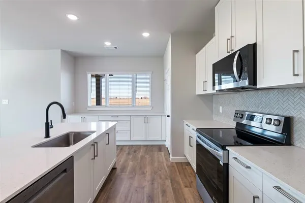 a kitchen with stainless steel appliances granite countertop a sink stove and microwave