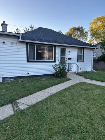 a front view of a house with a garden and yard