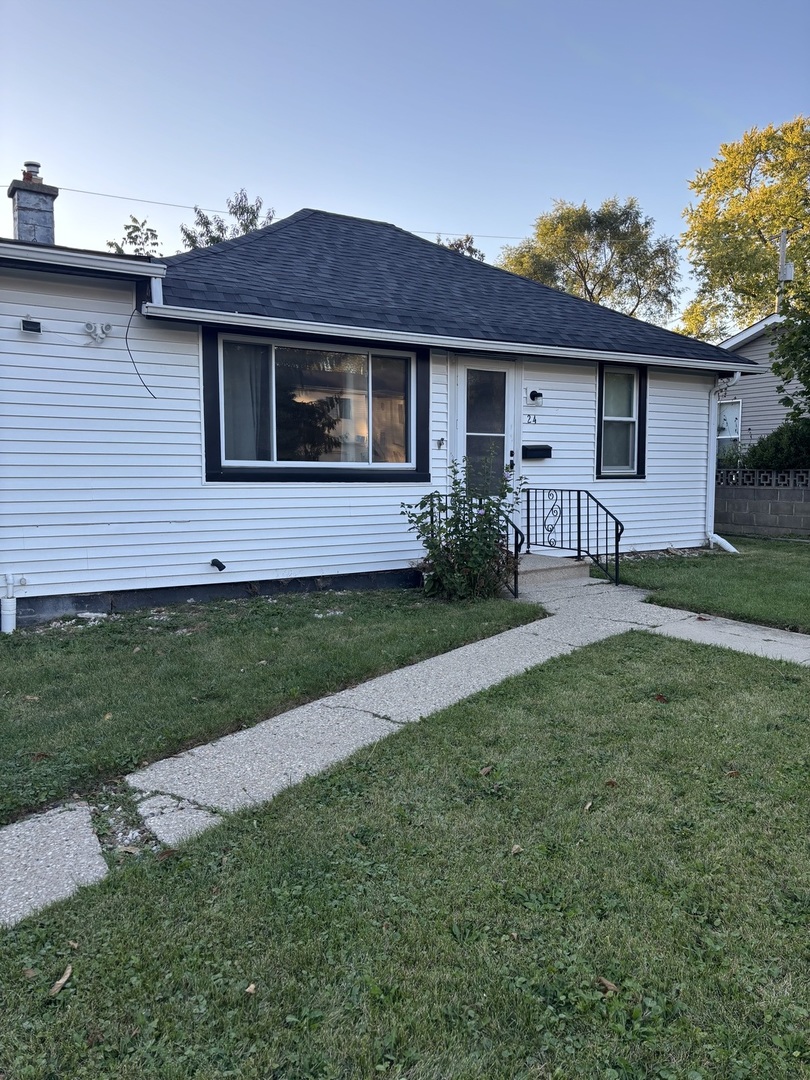 24 Washington Terrace Waukegan, IL 60085 - Photo 2 of 5 a front view of a house with a garden and yard