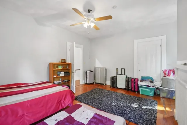 a bedroom with a bed dresser and a chandelier