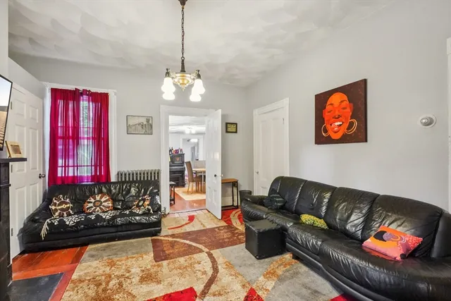 a living room with furniture chandelier and a rug