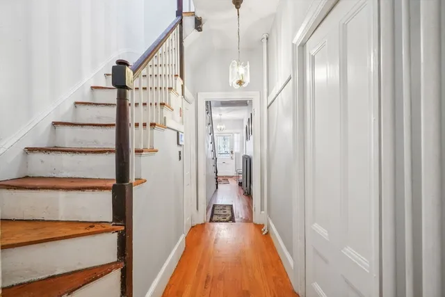 a view of a hallway with wooden floor and staircase
