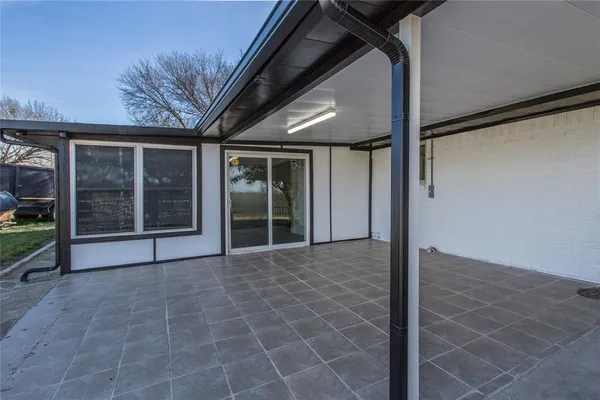 an empty room with windows and ceiling fan